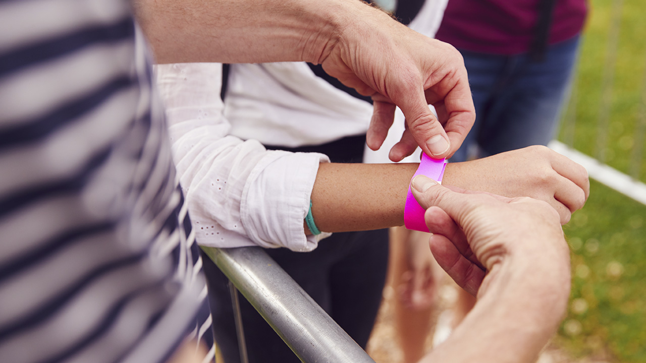 ¿Cómo promocionar tu festival con una pulsera personalizada? 3 close up of friends at entrance to music festival 2024 10 19 10 54 54 utc